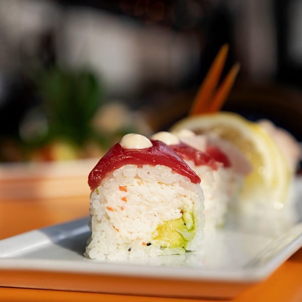 Sakana Sushi Lounge DTLA's sushi roll with tuna, avocado, and white sauce on a white plate.